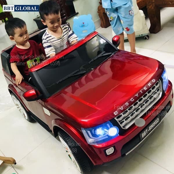 Hình ảnh xe ô tô trẻ em Land Rover màu trắng đỗ trên sân gạch