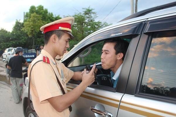 Một cảnh sát giao thông đang kiểm tra nồng độ cồn xe máy mới nhất bằng máy đo chuyên dụng.