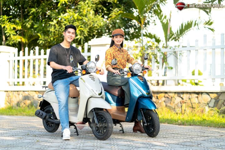 Một cô gái trẻ vui vẻ lái xe tay ga 50cc màu hồng trên đường phố, biểu tượng cho sự tự do và tiện lợi không cần bằng lái