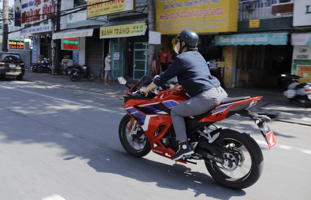 Một người ngồi trên xe máy nhìn ra khung cảnh thành phố, thể hiện sự kiểm soát và định hướng tương lai khi nằm mơ thấy mình đang chạy xe máy