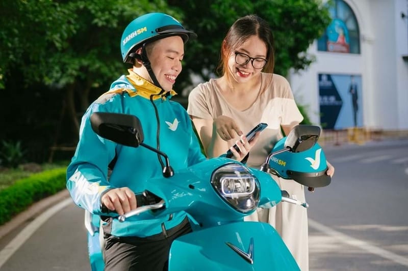 Một tài xế Xanh SM đang nở nụ cười, thể hiện thái độ thân thiện và chuyên nghiệp khi phục vụ khách hàng.