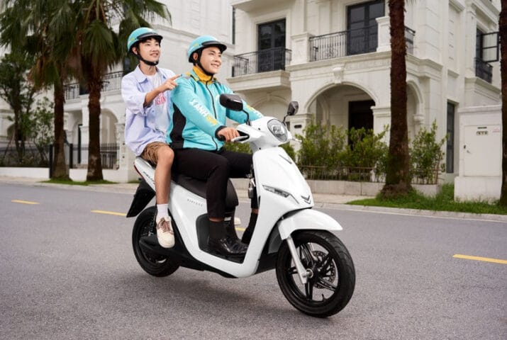 Người tài xế Xanh SM đang điều khiển xe máy điện VinFast trên đường đô thị, thể hiện sự chuyên nghiệp và thân thiện môi trường.