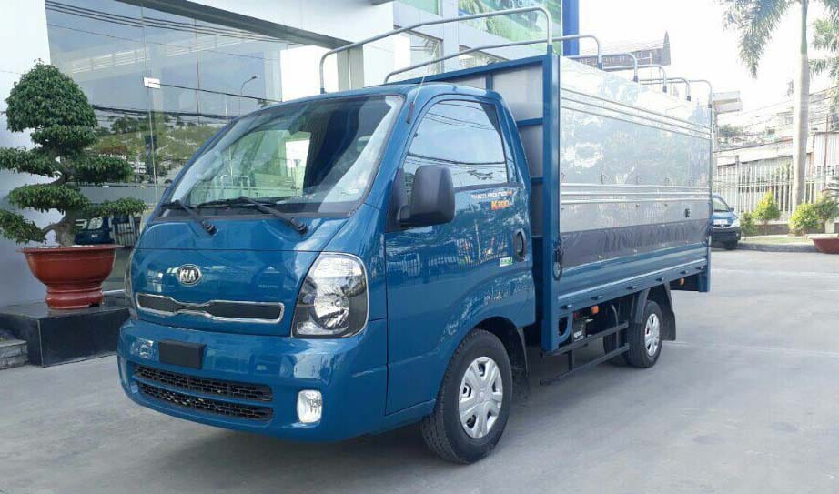 Thaco Kia Frontier K200 thùng mui bạt màu xanh lam đang đỗ cạnh một ngôi nhà, thể hiện sự đa dạng mẫu mã và ứng dụng của dòng **xe tải trọng 1.5 tấn** này