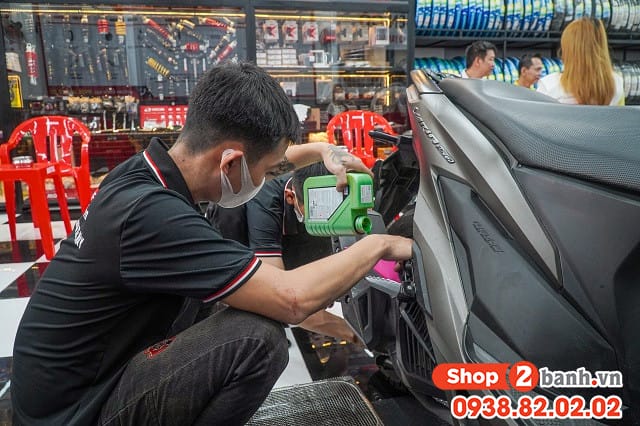 Thợ kỹ thuật đang kiểm tra và chuẩn bị thay nhớt xe tay ga định kỳ để duy trì hiệu suất động cơ.