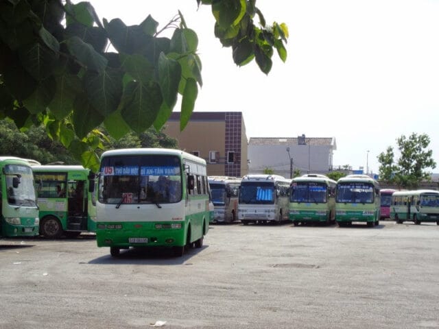 Xe buýt màu vàng chạy trên đường cao tốc với biển báo giao thông.