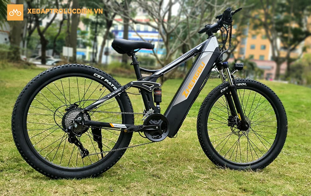 Xe đạp điện thể thao màu đen gập gọn với lốp dày, đặt cạnh khu vực nhà ở