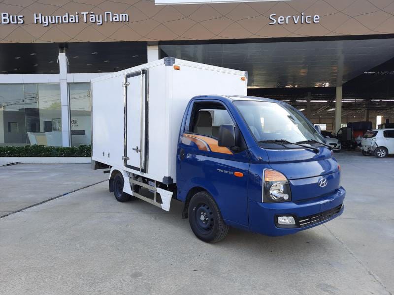 Xe tải Hyundai Porter H150 màu trắng đang đỗ trên một con đường, minh họa khối động cơ D4CB mạnh mẽ và lợi ích cao của **giá xe tải nhỏ 1.5 tấn**