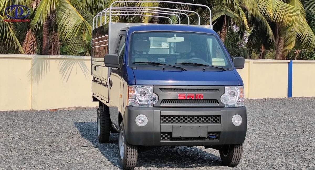 Xe tải SRM K990 màu xanh lam nhỏ gọn đang di chuyển trên đường phố, minh họa khả năng linh hoạt cho việc vận chuyển hàng hóa nội thành